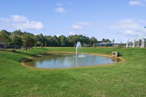 greenspace area with a pond and fountain at Park at Magnolia apartments
