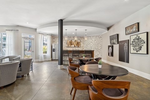 A modern dining room with a stone wall and wooden chairs.