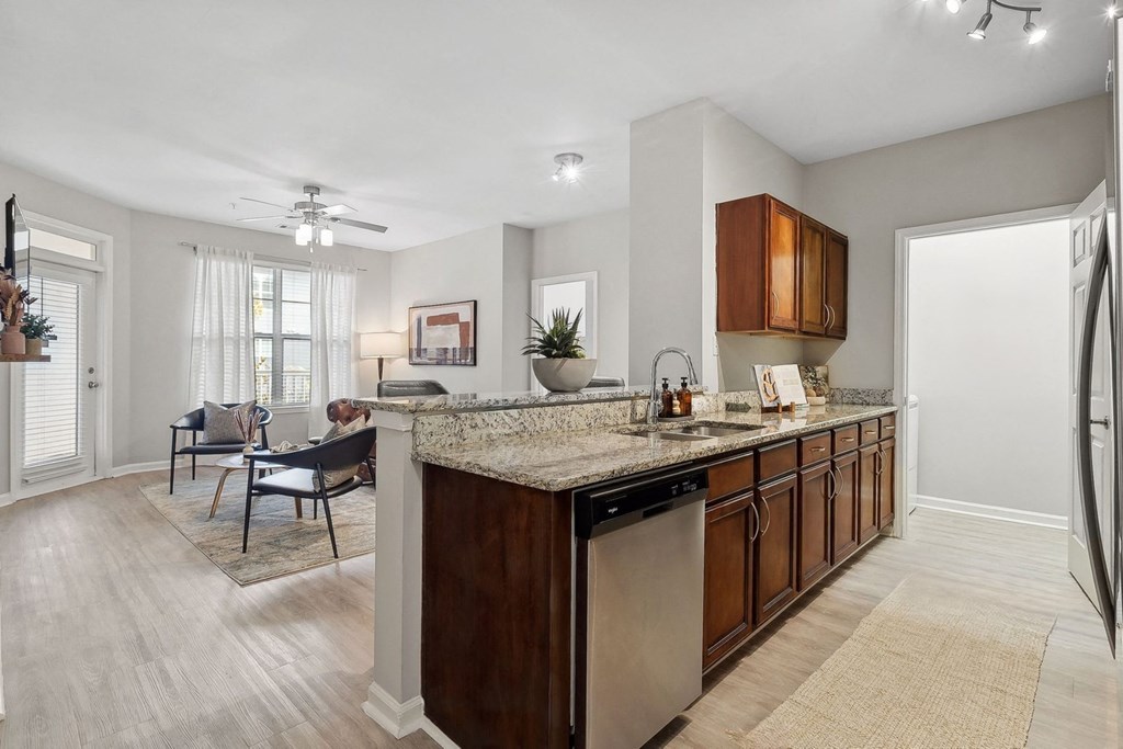 spacious open-concept kitchen and living area with hardwood-inspired flooring at Sorelle apartments