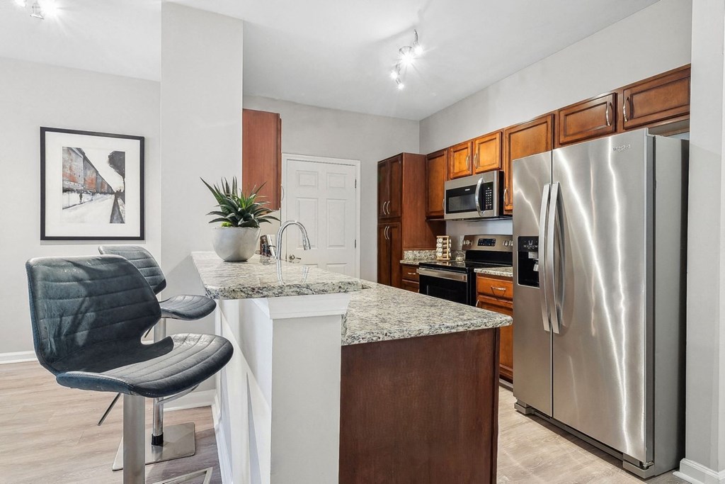 luxury kitchen with granite countertops including a bar and stainless appliances at Sorelle apartments