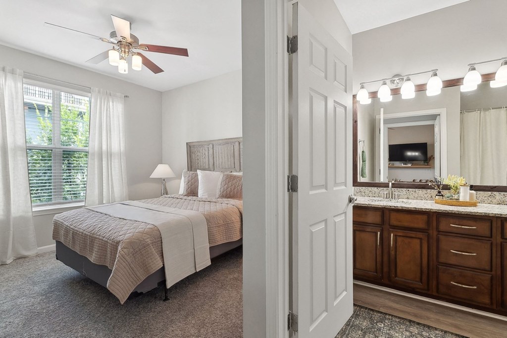 spacious bedroom with a lighted-ceiling fan and bathroom at Sorelle apartments
