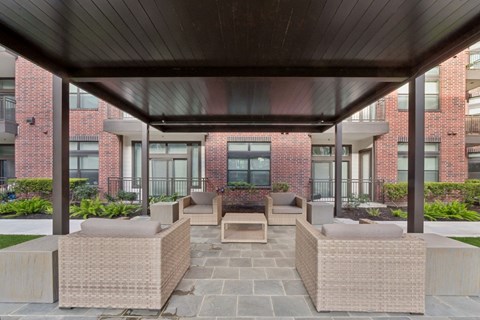 A patio with a table and chairs under a roof.