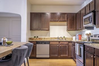 luxury kitchen with granite countertops and custom cabinetry at The Pradera apartments