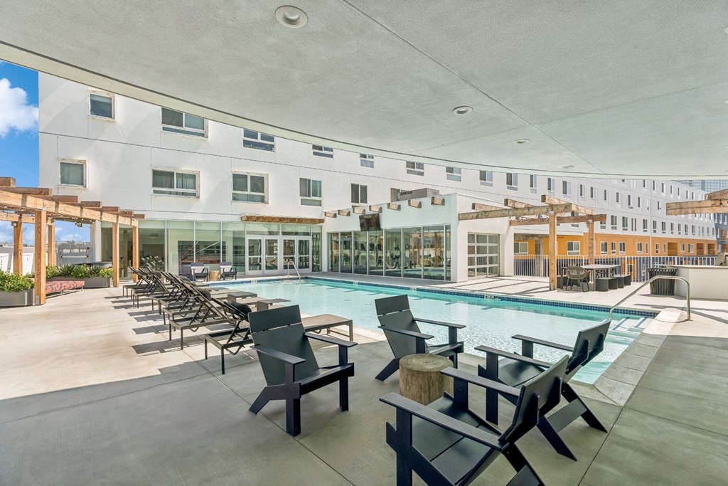 swimming pool with sun deck and covered lounging areas at One Santa Fe apartments