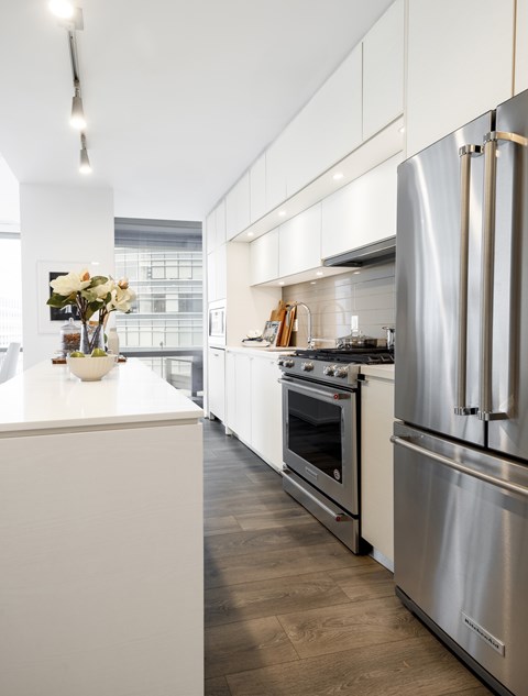 A modern kitchen with stainless steel appliances and white cabinetry.