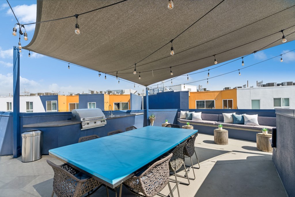 outdoor covered patio with grills and al fresco dining and lounging area at One Santa Fe apartments