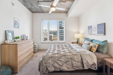 A bedroom with a large bed and a wooden dresser.