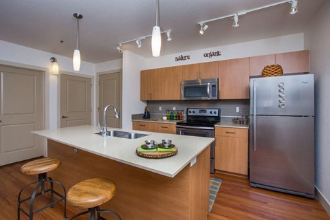 a kitchen with wooden cabinets and stainless steel appliances and a white counter top