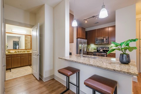 a kitchen with a granite counter top and a bar with stools