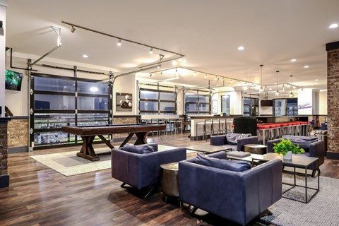 a lounge area with couches and tables and a pool table
