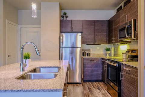spacious kitchen with stainless steel appliances and granite counter tops at The Allure luxury apartments