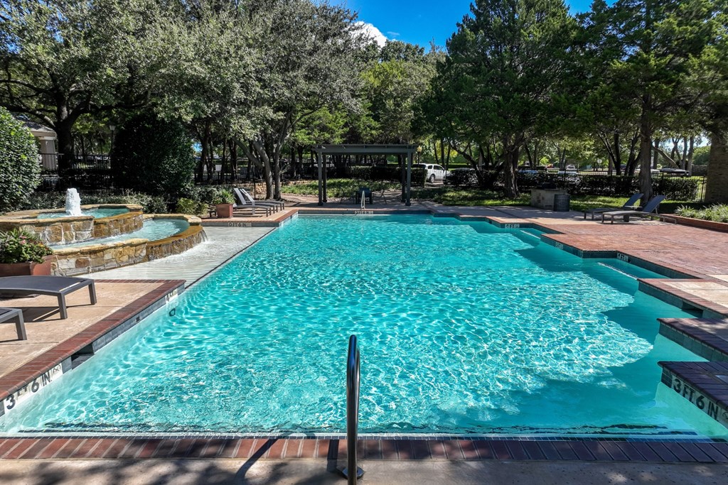 swimming pool with a fountain at Stoneleigh on Spring Creek apartments