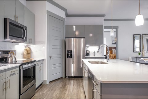 luxury kitchen with stainless steel appliances at Reveal Skyline apartments
