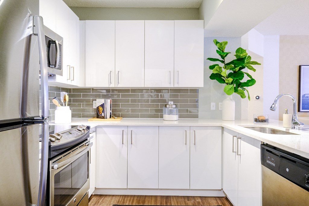 Kitchen with custom white cabinetry and stainless appliances at Sophia at Abacoa luxury Jupiter, FL apartments