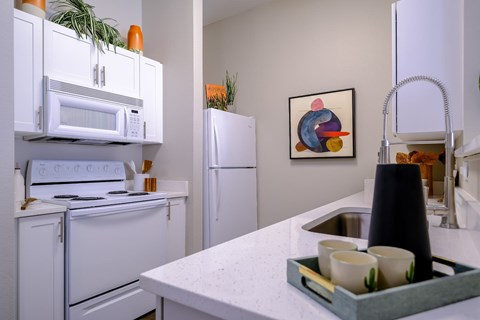 A kitchen with white appliances and a white countertop.