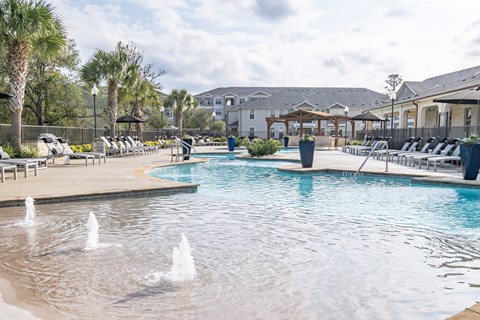 A pool with water fountains in the middle of it.