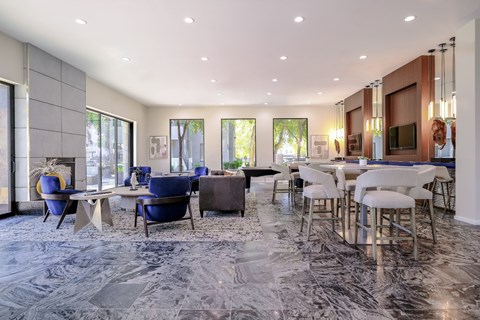 A modern dining room with a marble floor and a long table set for a meal.