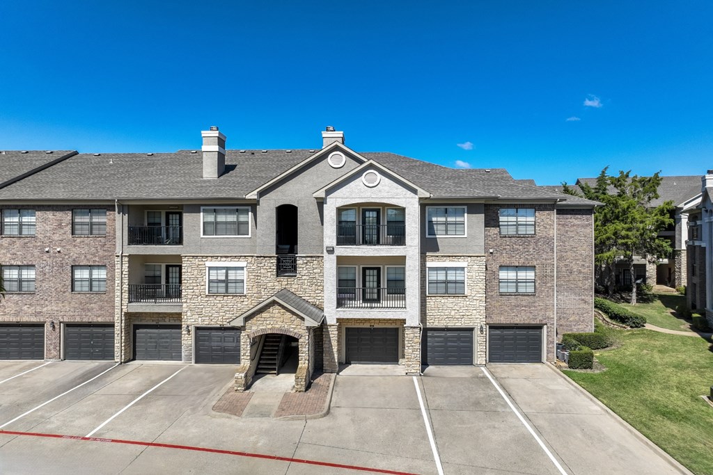 exterior view of Stoneleigh on Spring Creek apartments with garages in Garland, TX