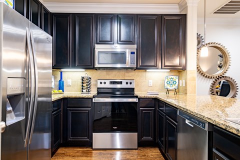 A kitchen with black cabinets and stainless steel appliances.