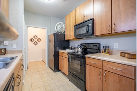 a kitchen with wooden cabinets at Verano apartments