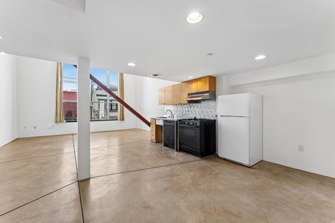 A kitchen area with a white refrigerator, black oven, and a white countertop.