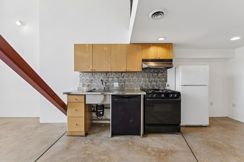 A kitchen with a black stove top oven and a white refrigerator.