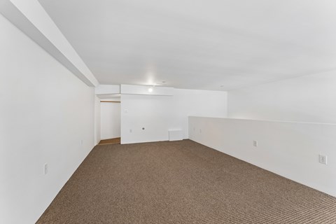 A room with carpeted floor and white walls.