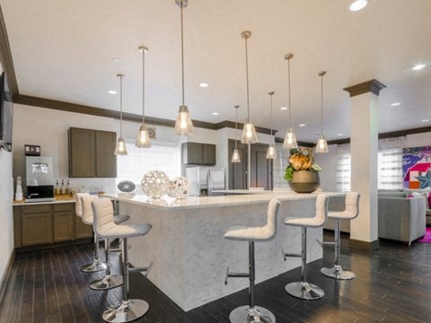 a large kitchen with a bar and chairs