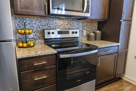 A modern kitchen with a stainless steel oven and microwave.