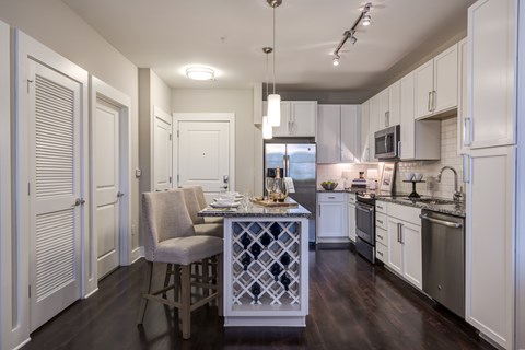 A kitchen with a table and chairs in the middle.