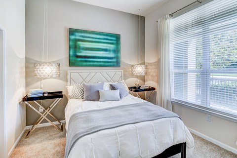 A bedroom with a large bed and a painting on the wall.