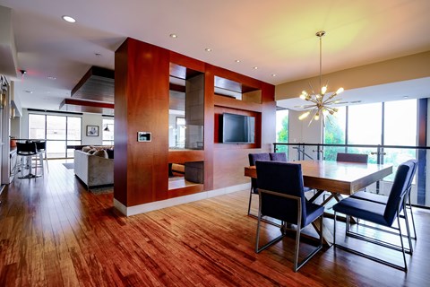 A modern dining room with a wooden table and chairs.