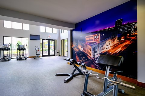 A gym with a wall mural of a cityscape at night.
