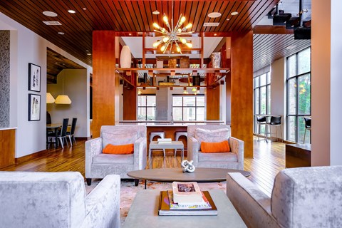A living room with a grey couch and a wooden ceiling.