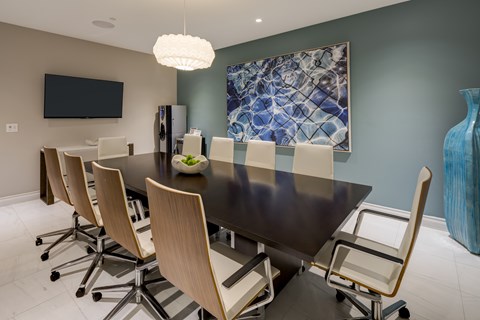 A modern dining room with a large table and chairs.