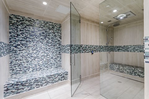 A bathroom with a walk-in shower and a bench seat.