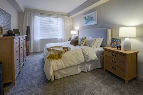 A bedroom with a bed, nightstand, and dresser.
