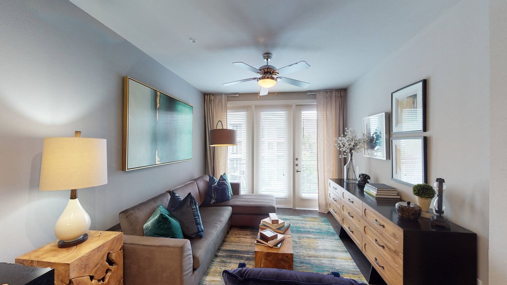 a living room with a ceiling fan and a large window