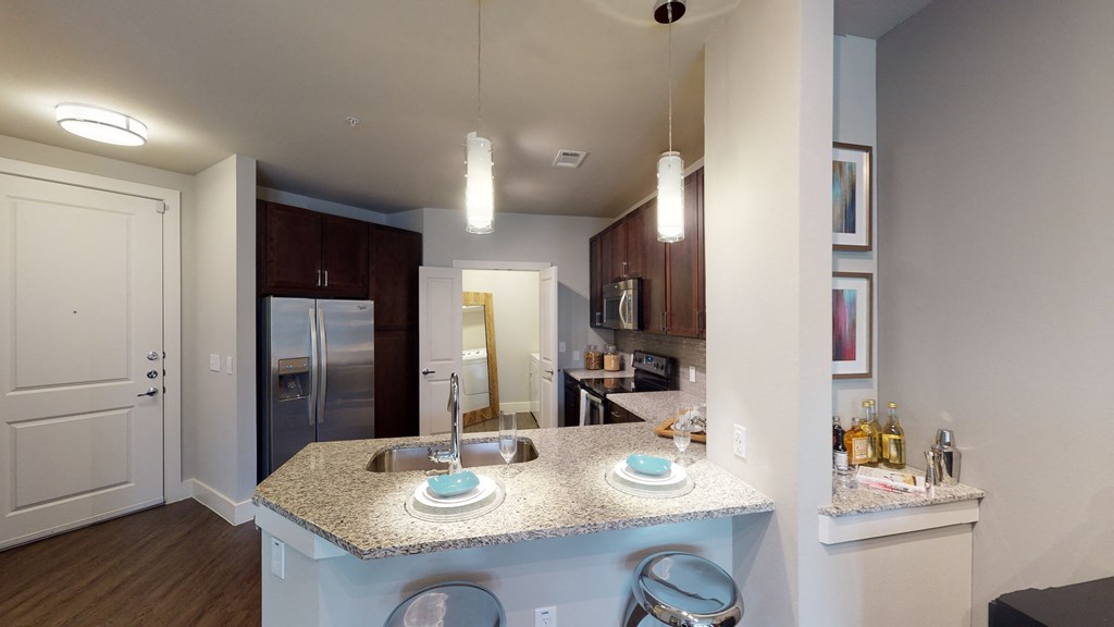 a kitchen with granite countertops and stainless steel appliances