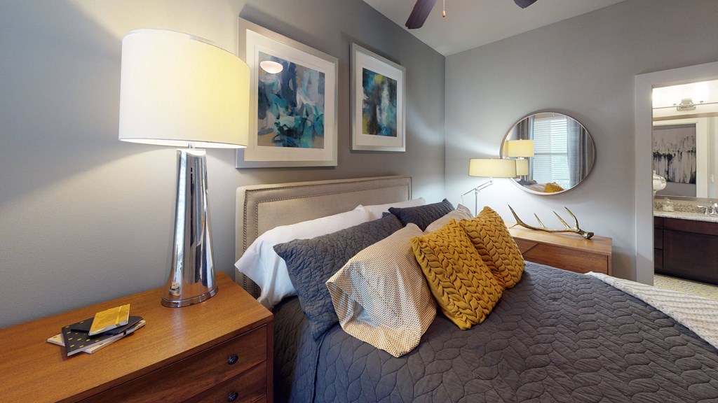 a bedroom with a bed and a dresser with a mirror on the wall