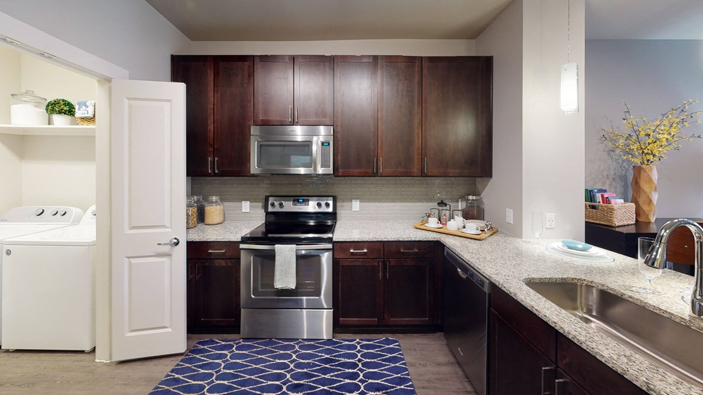 a kitchen with dark wood cabinets and a blue rug