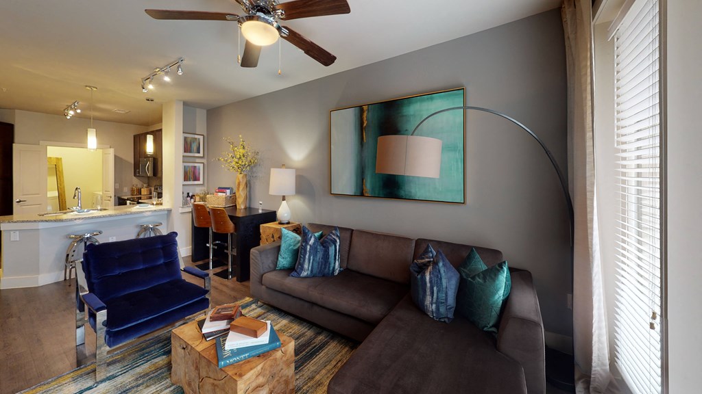 a living room filled with furniture and a ceiling fan