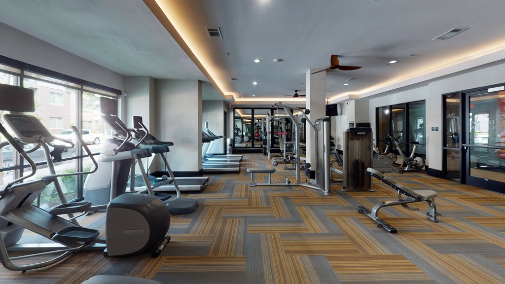 a large fitness room with treadmills and other exercise equipment