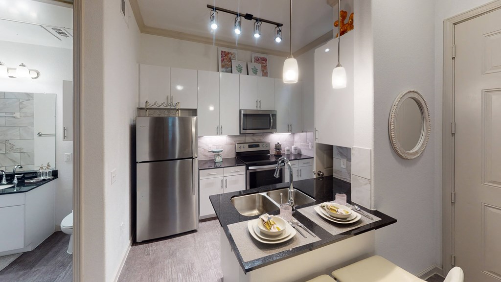 a kitchen with white cabinetry and stainless steel appliances