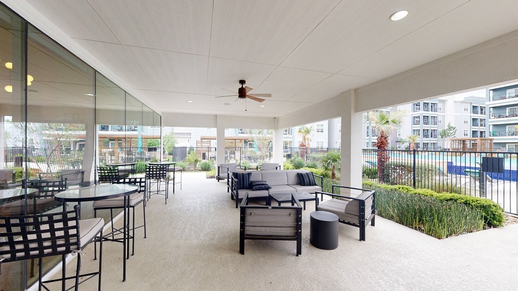 a patio with couches and chairs and a ceiling fan