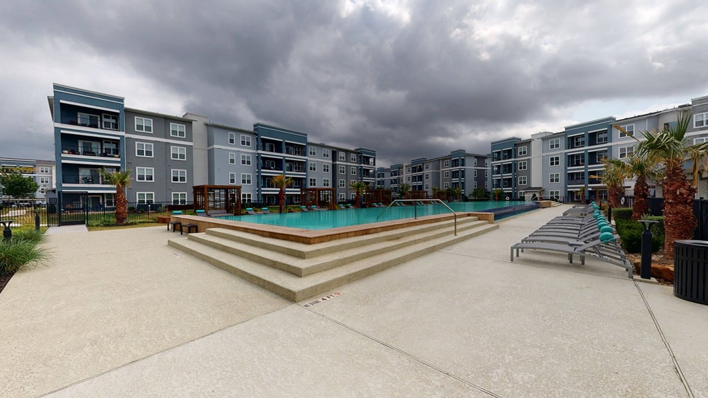 a large swimming pool in front of an apartment building