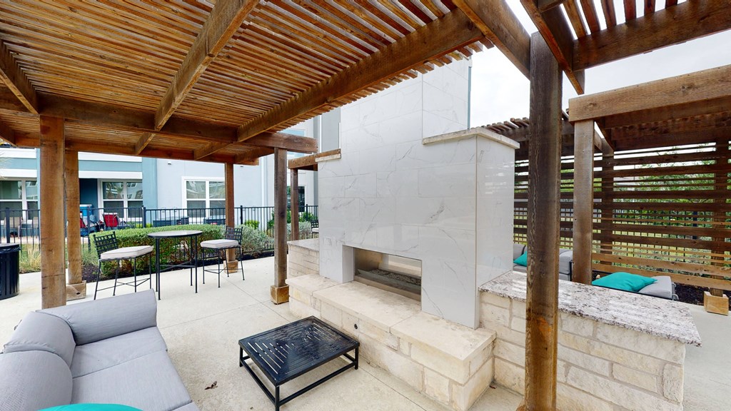 a patio with a fireplace and a pergola