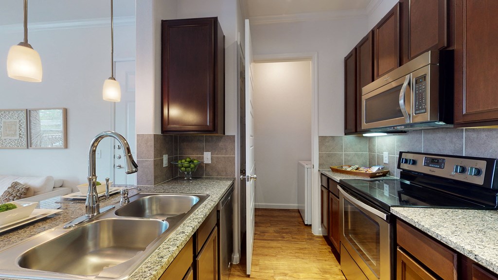 a kitchen with dark wood cabinets and granite countertops