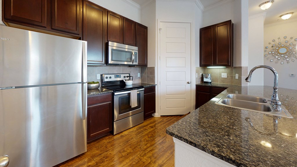 a kitchen with stainless steel appliances and granite countertops