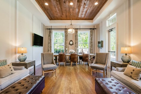 Alexander Village Clubhouse interior view with wood flooring, couches, and arm chairs